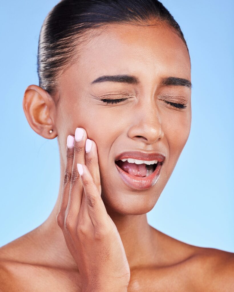 Toothache, cavity and a woman with mouth pain on a blue background with a dental emergency. Dentist