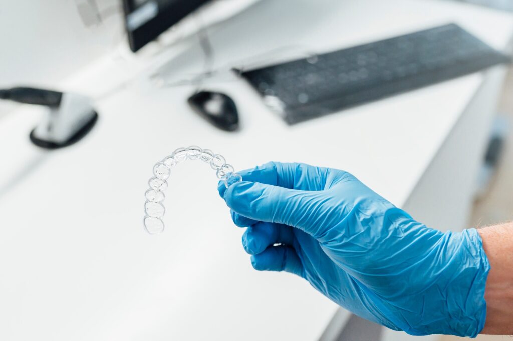 Doctor hand holding a clear dental aligner